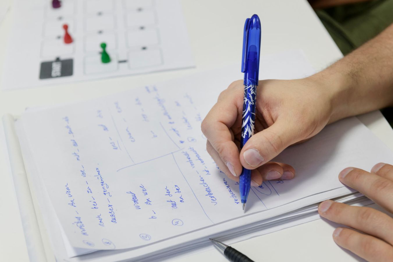 Reaching their goal step by step: Participants may move their game pieces forward for each correct answer. Their answers are noted and then corrected.